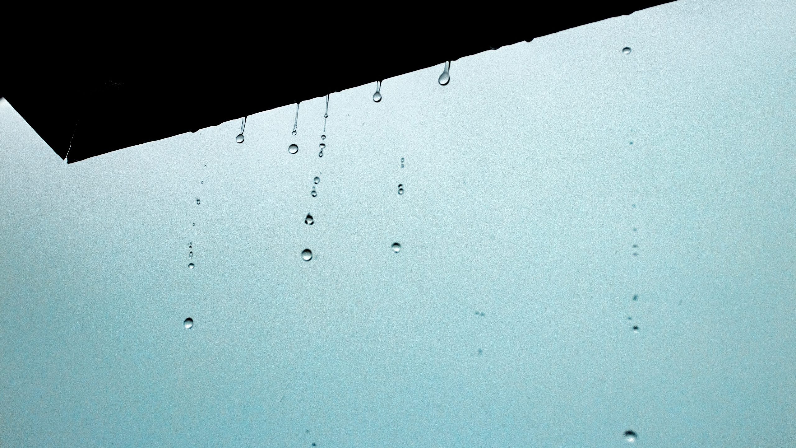 Water drops drippng from edge of roof illustrate blog "How To Protect Your Roof From Hail Damage"