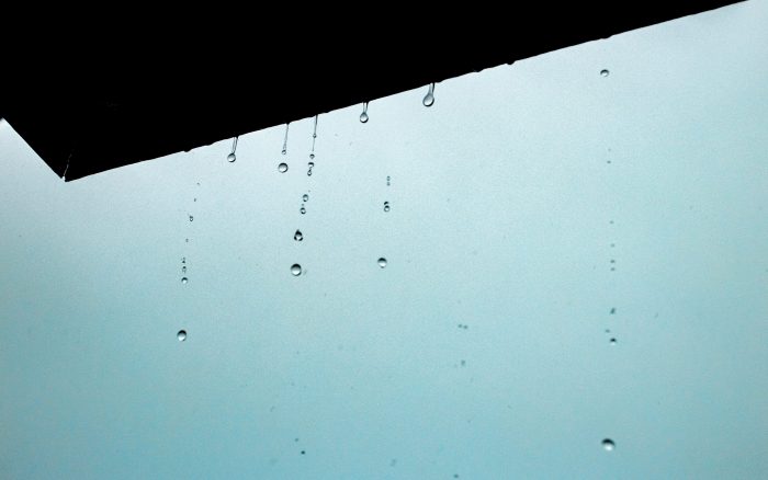 Water drops drippng from edge of roof illustrate blog "How To Protect Your Roof From Hail Damage"