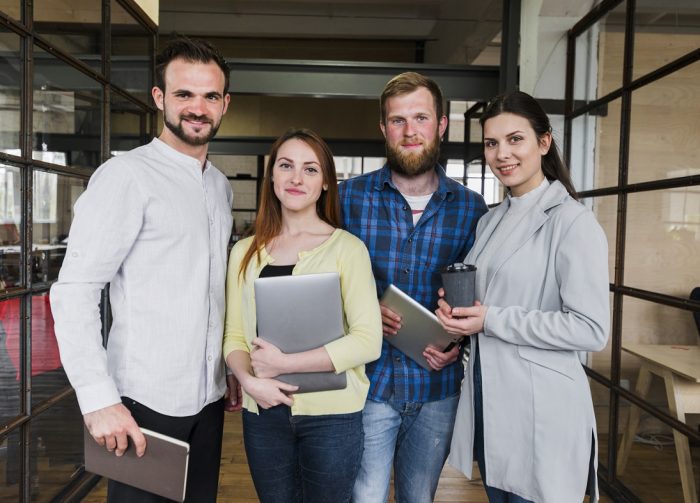 Business owners posing for photo illustrate blog "Addressing Common Commercial Roofing Challenges and Solutions"
